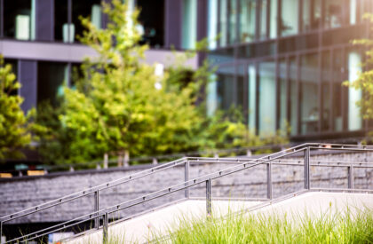 Stairs in front of glass buildings. Business office. Stairs in front of glass buildings. Business office. Park with trees and grass in front of the Business center.